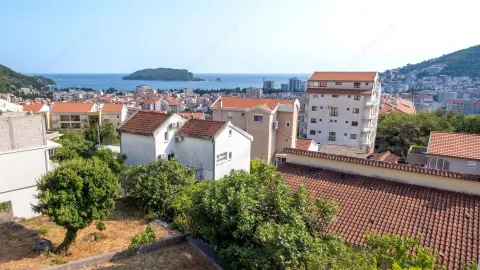 Pogled sa nekretnine na grad, krovove i more sa ostrvom u daljini. - image 27