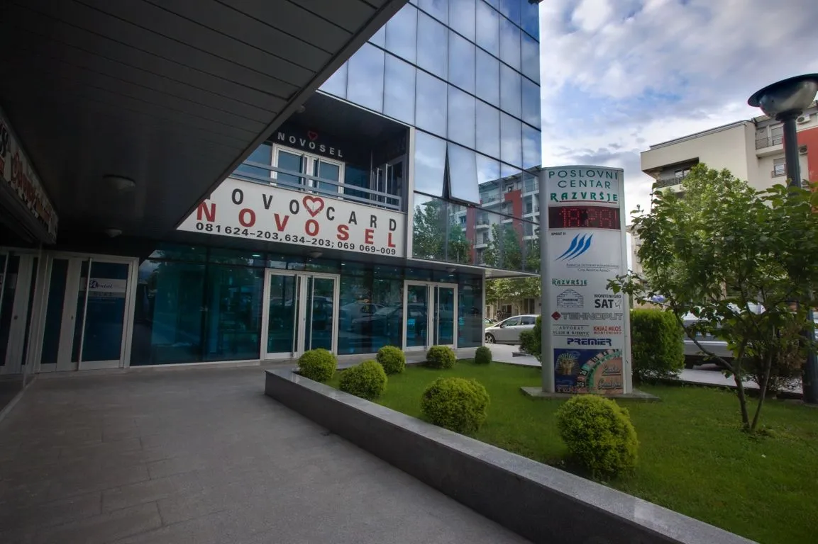 Exterior of the office building with a sign and landscaped entrance.