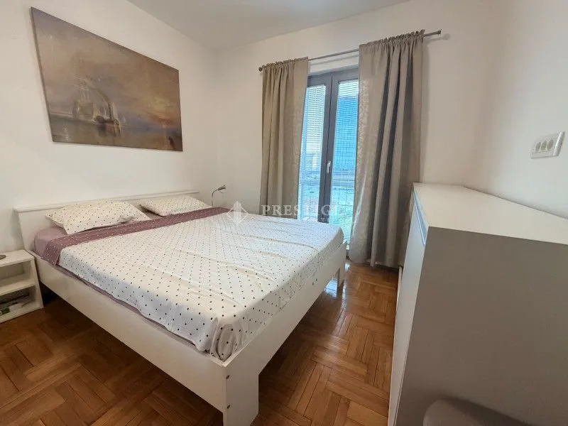 Bright and tidy bedroom with a double bed and parquet flooring.