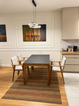 Dining area with a wooden table, modern chairs, and artwork on the wall. - image 6