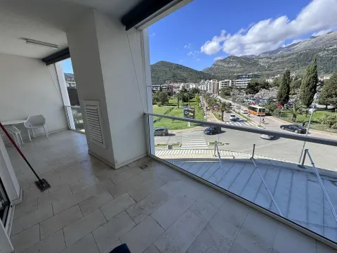 Prostrana natkrivena terasa sa staklenom ogradom i pogledom na grad i planine. - image 10