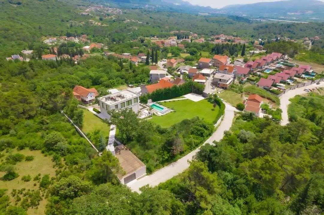 Pogled iz vazduha na imanje sa kućom, bazenom i okolinom.