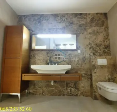 Moderno kupatilo sa umivaonikom, ogledalom, ormarićem i WC šoljom obloženo mermernim pločicama. - image 12