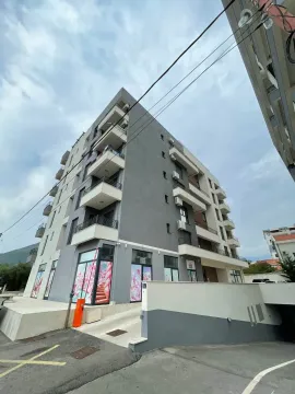 Exterior of a modern multi-family apartment building with balconies and a paved driveway. - image 7
