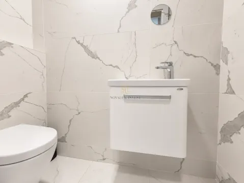 Modernly equipped bathroom with a washbasin and white marble-effect ceramic tiles. - image 13