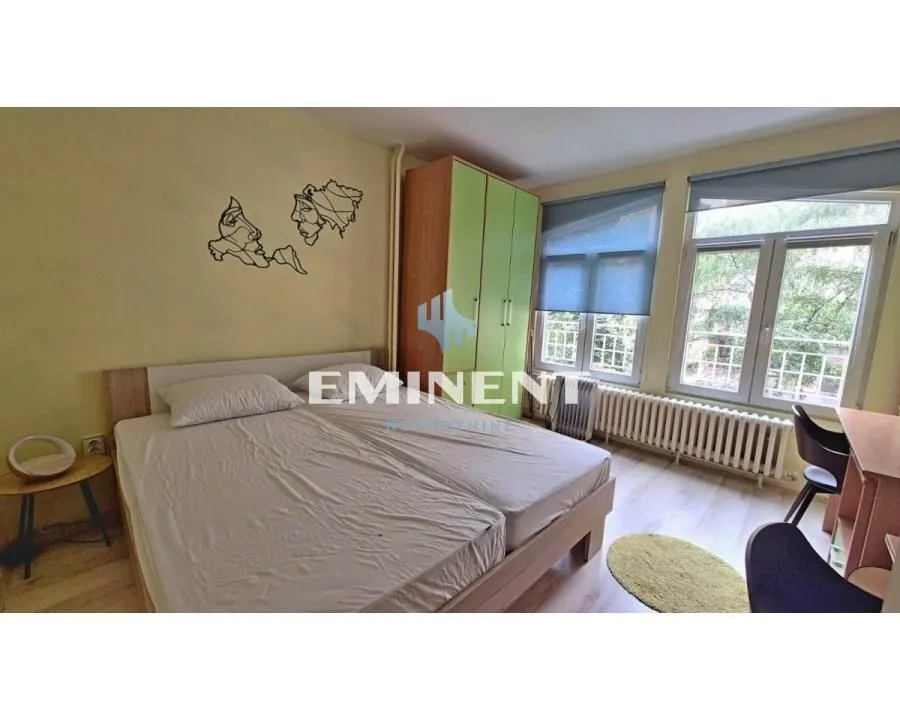 Furnished bedroom with a double bed, wardrobe, and a desk by the window.
