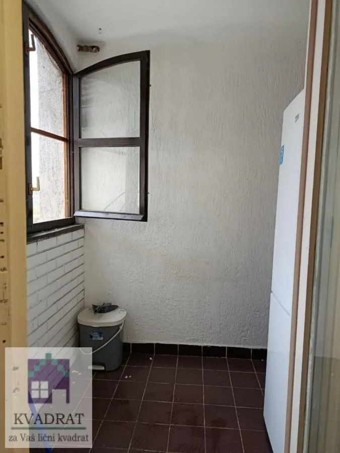 Manji zatvoreni balkon sa prozorom i frižiderom.