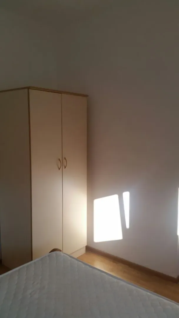 A simply furnished bedroom featuring a two-door wardrobe.