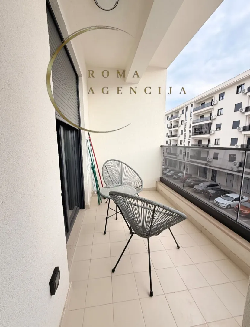 Small balcony with seating furniture and a view of the buildings.