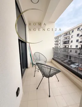 Small balcony with seating furniture and a view of the buildings. - image 10