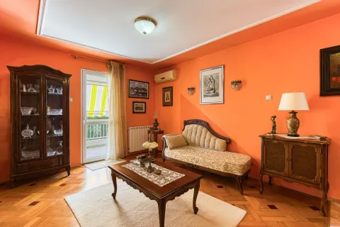Dnevna soba sa stilskim namještajem, narandžastim zidovima i izlazom na terasu. - image 9