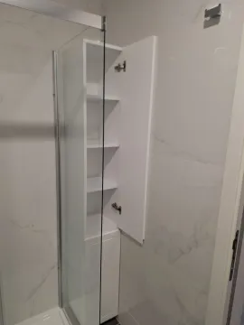 Svijetlo kupatilo sa bijelim ormarićem pored tuš kabine. - image 14