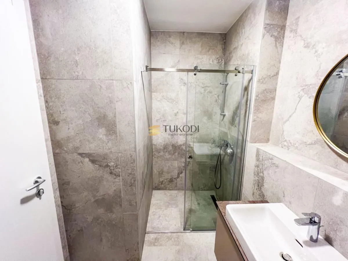 Modernly equipped bathroom with a shower cabin and a washbasin.