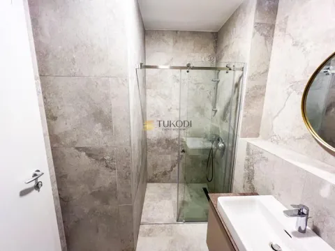 Modernly equipped bathroom with a shower cabin and a washbasin. - image 7