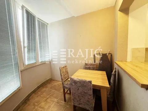 Small dining area with a table, chairs, and windows with blinds. - image 3