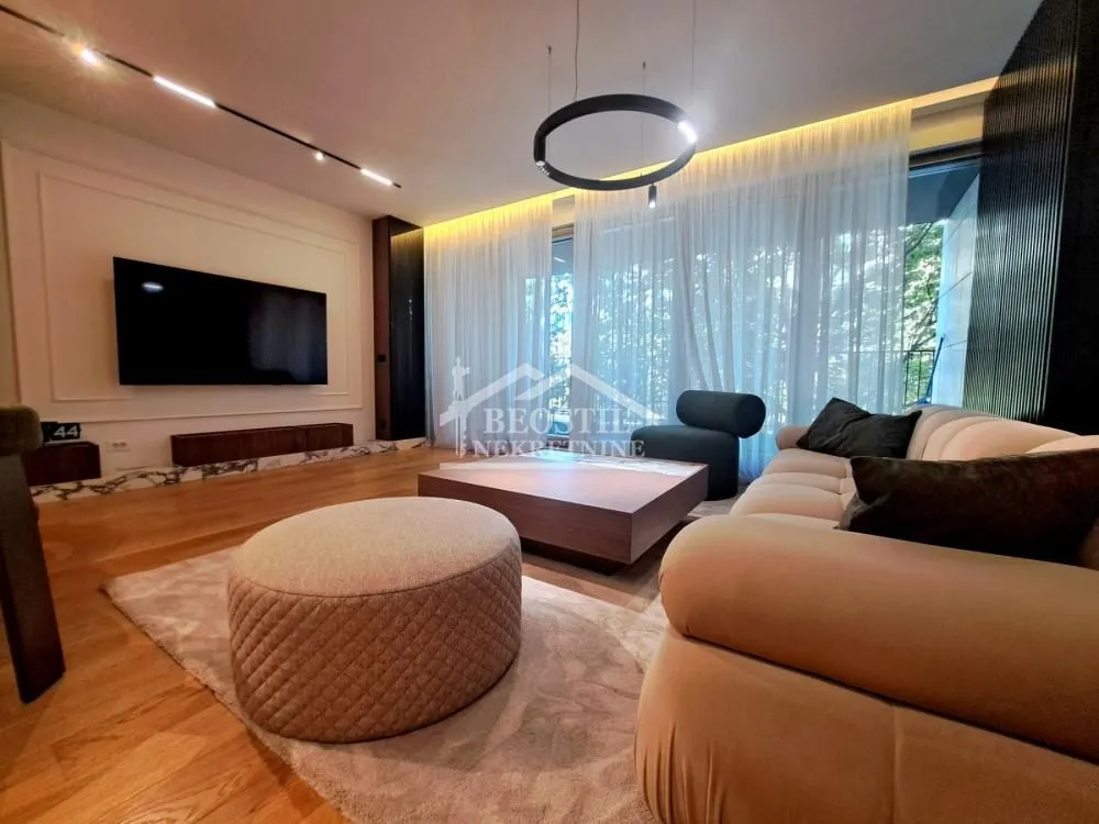 Modernly furnished living room with sofa and television.