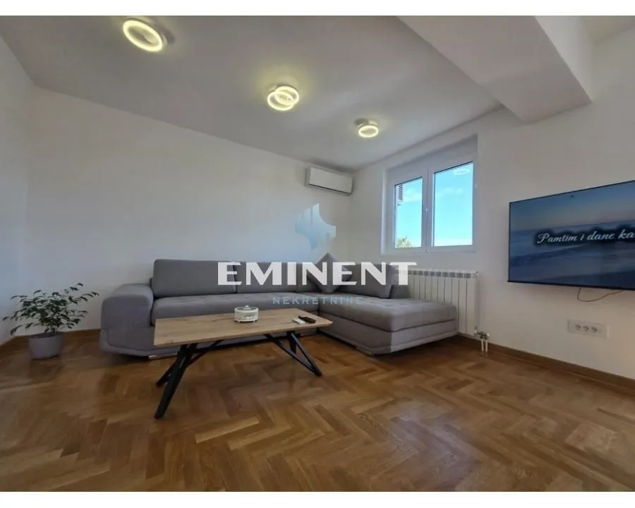 Living room with a sofa set, coffee table, and television.
