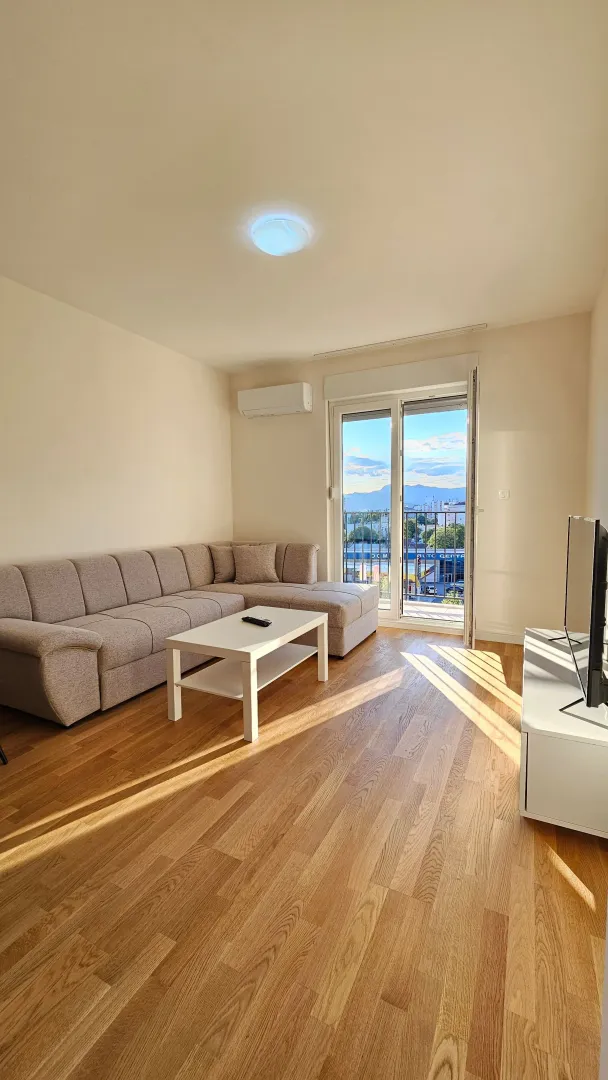 Living room with a sectional sofa, coffee table, and access to the balcony.
