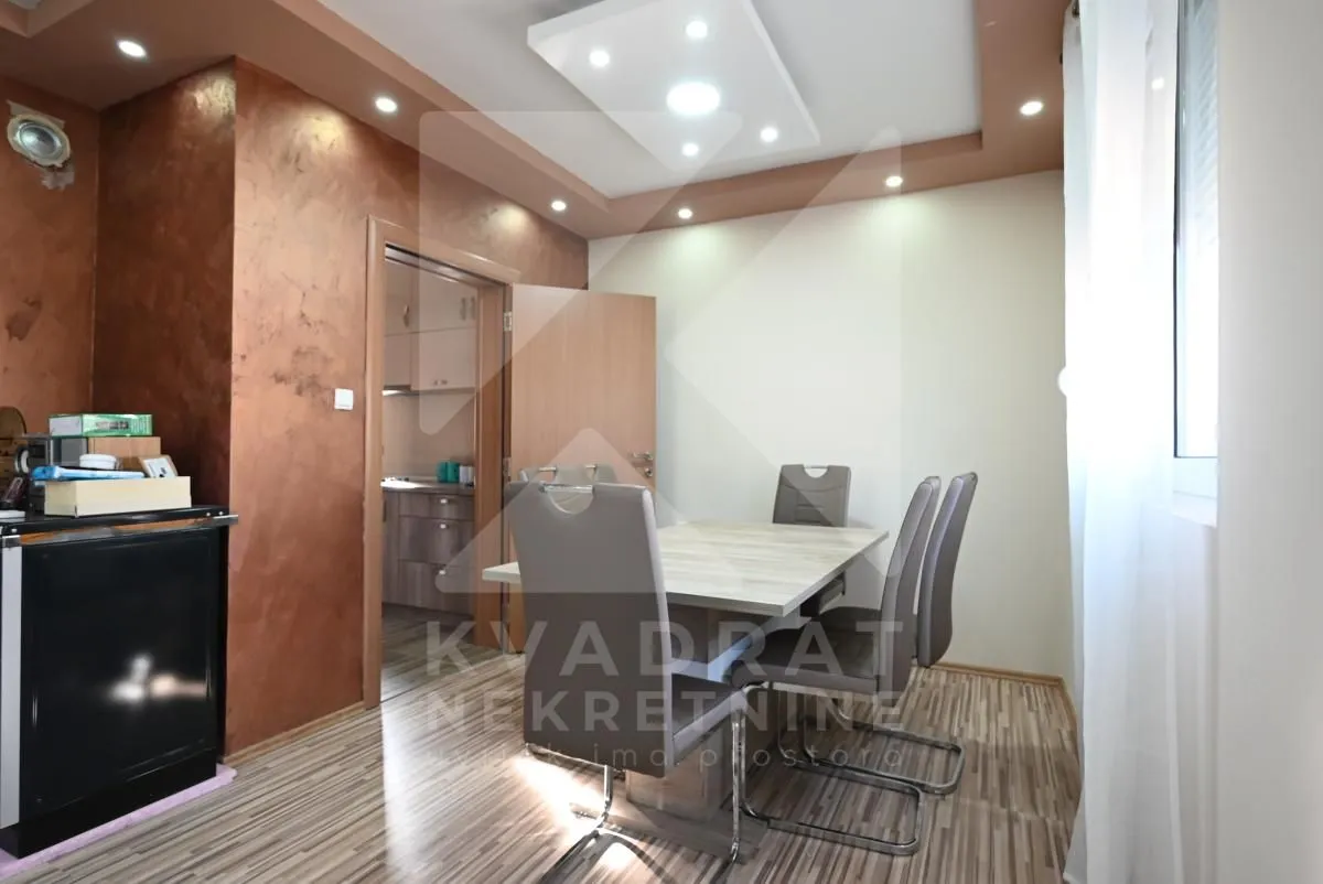 Dining area with a table, chairs, and a view of the kitchen.
