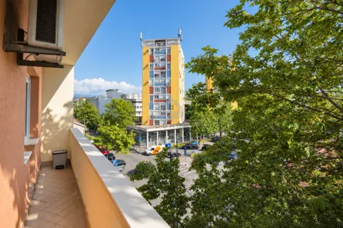 View from the balcony overlooking surrounding buildings and the street. - image 9