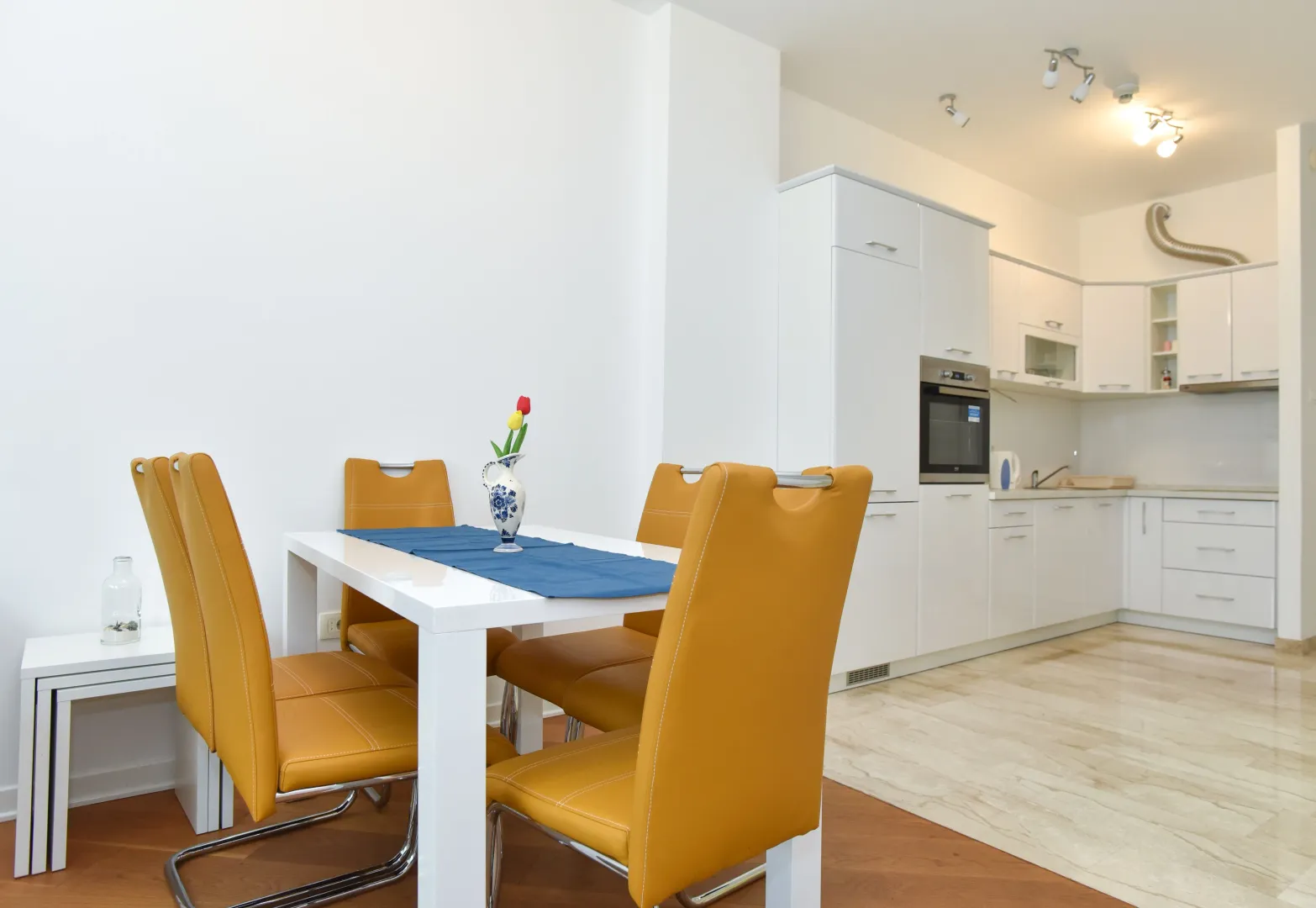 Modern kitchen with a dining area and white cabinetry.