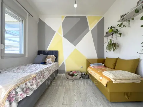 Dječja soba sa krevetom, kaučom i zidom ukrašenim geometrijskim šarama. - image 5