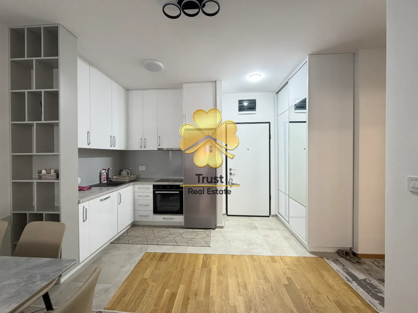 Modern white kitchen with built-in appliances and a dining area.