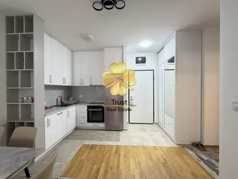 Modern white kitchen with built-in appliances and a dining area. - image 6
