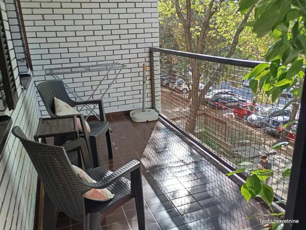 Furnished balcony with seating furniture and a street view.