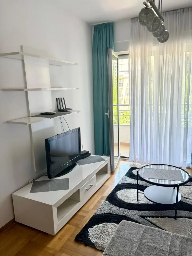 Living room with a TV unit, coffee table, and access to the terrace.