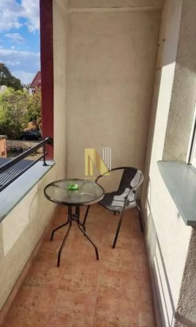 Manji zatvoreni balkon sa stolom i stolicom.