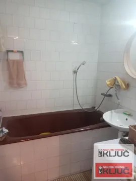 Kupatilo sa kadom, umivaonikom i belim zidnim pločicama. - image 13
