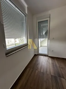 Prazna soba sa prozorom, balkonskim vratima i laminatom na podu. - image 7