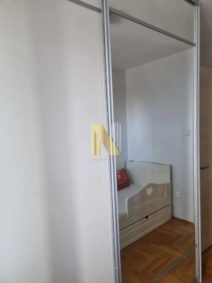 Dečija soba sa krevetom i ugradnim plakarom sa ogledalom.