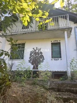 Pogled na fasadu dvospratne kuće sa balkonom i zelenilom u dvorištu. - image 3