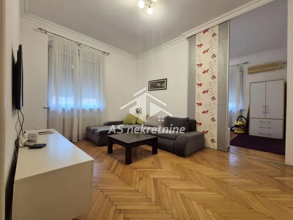 Living room with a sofa set and parquet flooring.