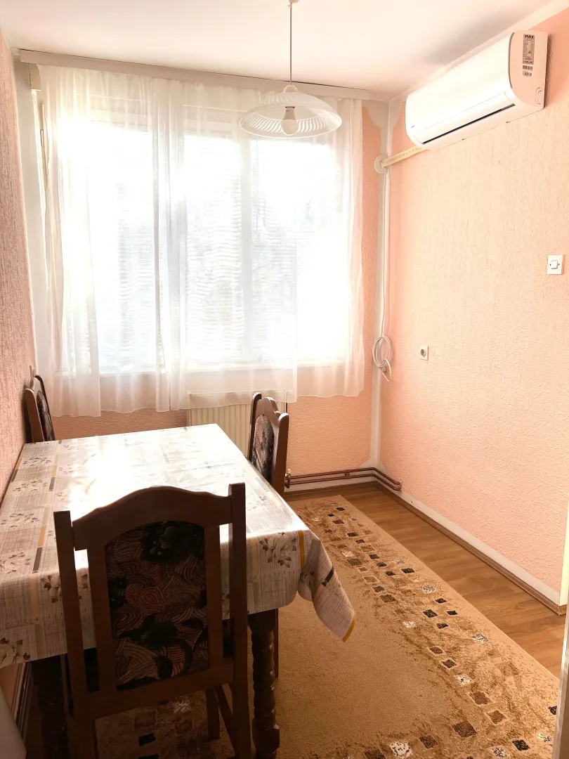 Trpezarija sa stolom, stolicama i prozorom.
