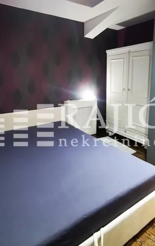 Furnished bedroom with a double bed and a wardrobe.