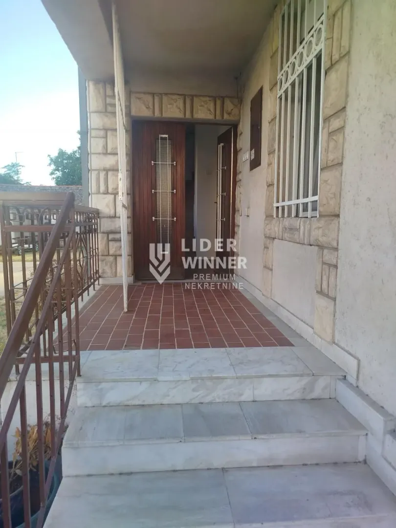 Entrance to the house with stairs and a tiled terrace.