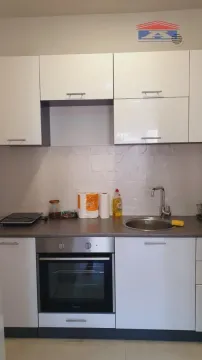 Small kitchen with white cabinets, built-in oven, and sink. - image 3