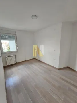 Prazna soba sa belim zidovima i drvenim podom. - image 7