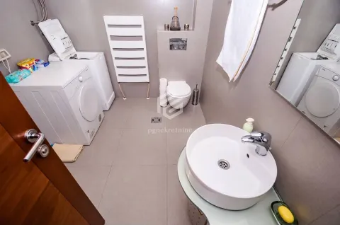 Bathroom equipped with a washbasin, toilet, washing machine, and towel radiator. - image 3