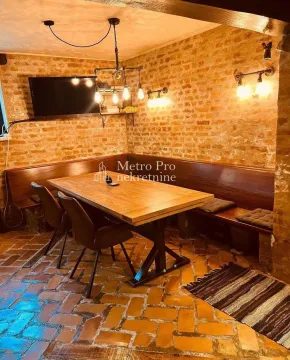 Rustična trpezarija sa drvenim stolom i zidovima od cigle. - image 19