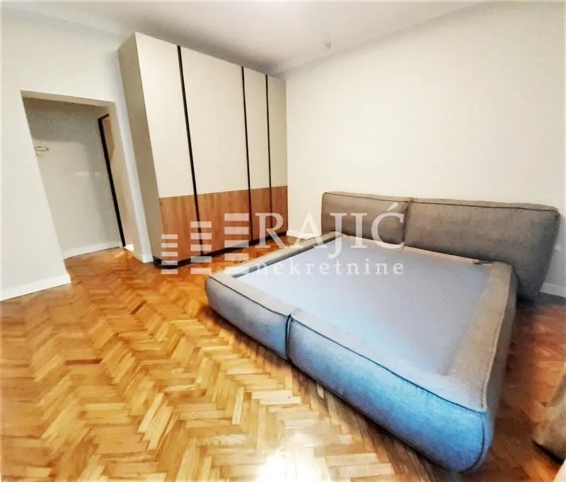 Bedroom with a double bed, large wardrobe, and parquet flooring.
