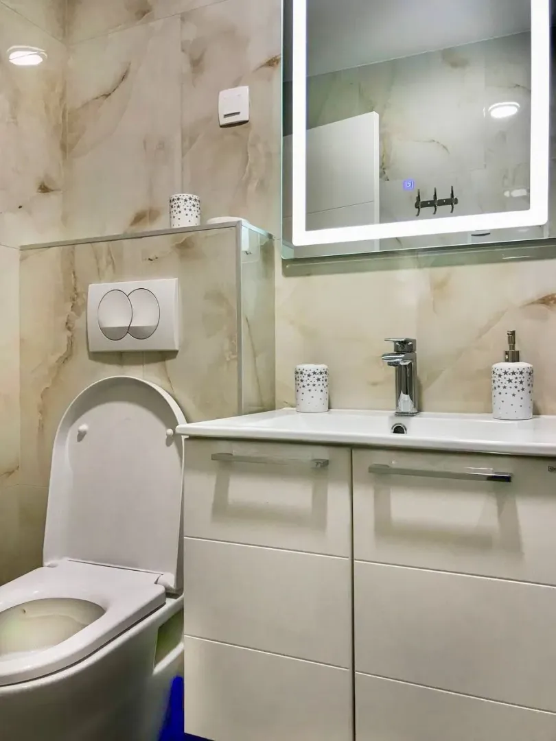 Moderne kupatilo sa umivaonikom, WC šoljom i ogledalom sa pozadinskim osvjetljenjem.