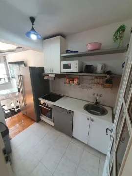 Small equipped kitchen with white cabinets and built-in appliances. - image 4