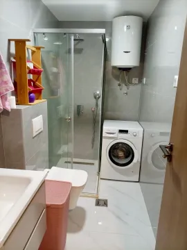 Modernly equipped bathroom with a shower cabin and washing machine. - image 5
