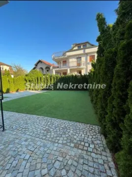 Yard with a lawn and paved area in front of the house. - image 5