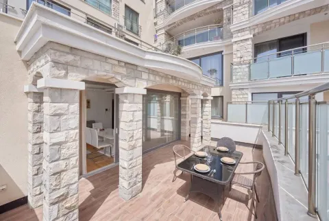 Spacious terrace with dining furniture and a view of the building. - image 5