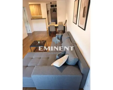 Living room with a sofa and a view towards the dining area and kitchen. - image 17